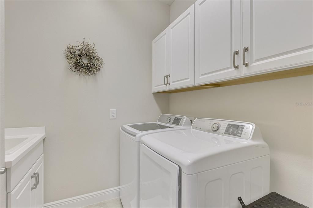 Inside laundry room with utility sink and cabinetry