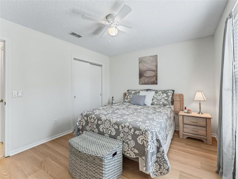 Guest bedroom with closet and beautiful flooring.