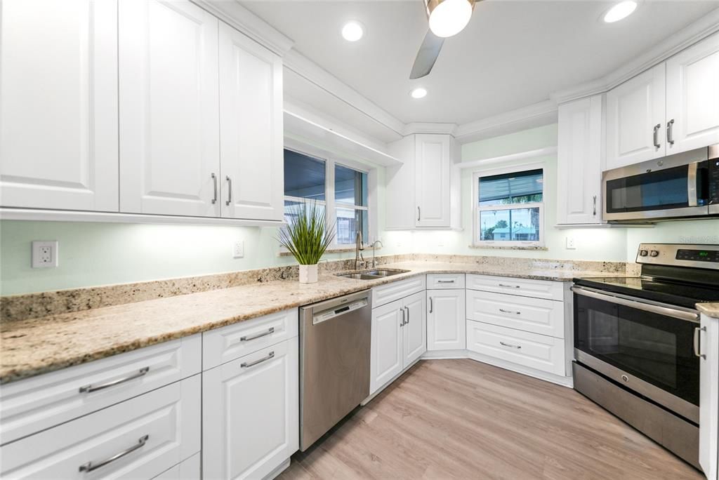 Kitchen with White Cabinetry, Crown Molding, Granite Countertops and Recessed Lighting