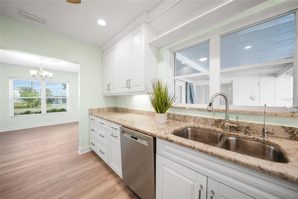 Kitchen with White Cabinetry, Crown Molding, Granite Countertops and Recessed Lighting