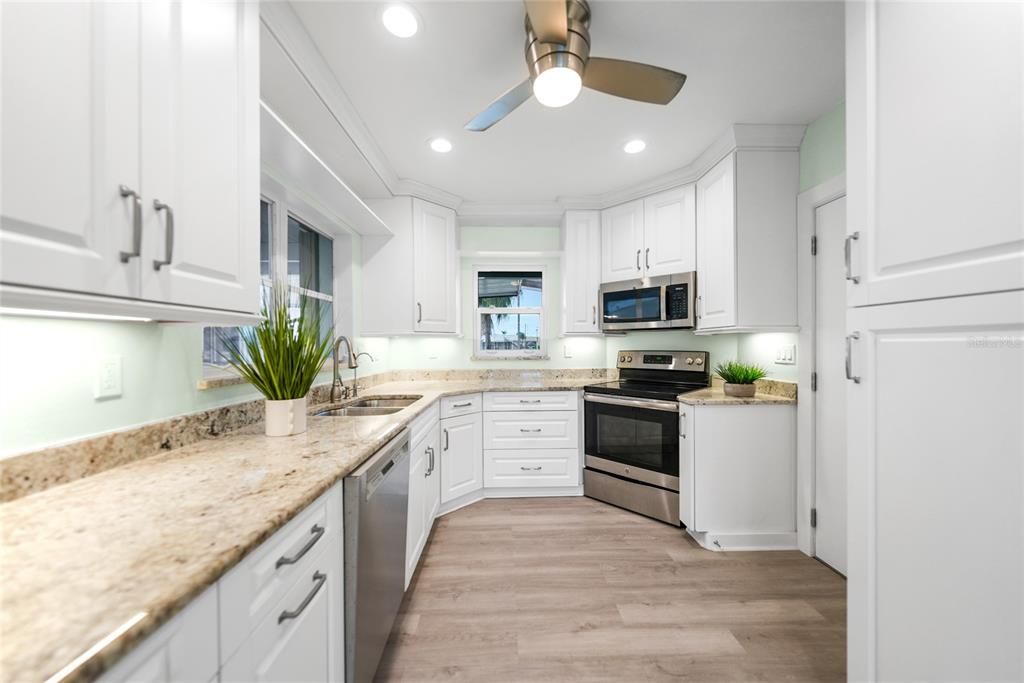 Kitchen with White Cabinetry, Crown Molding, Granite Countertops and Recessed Lighting