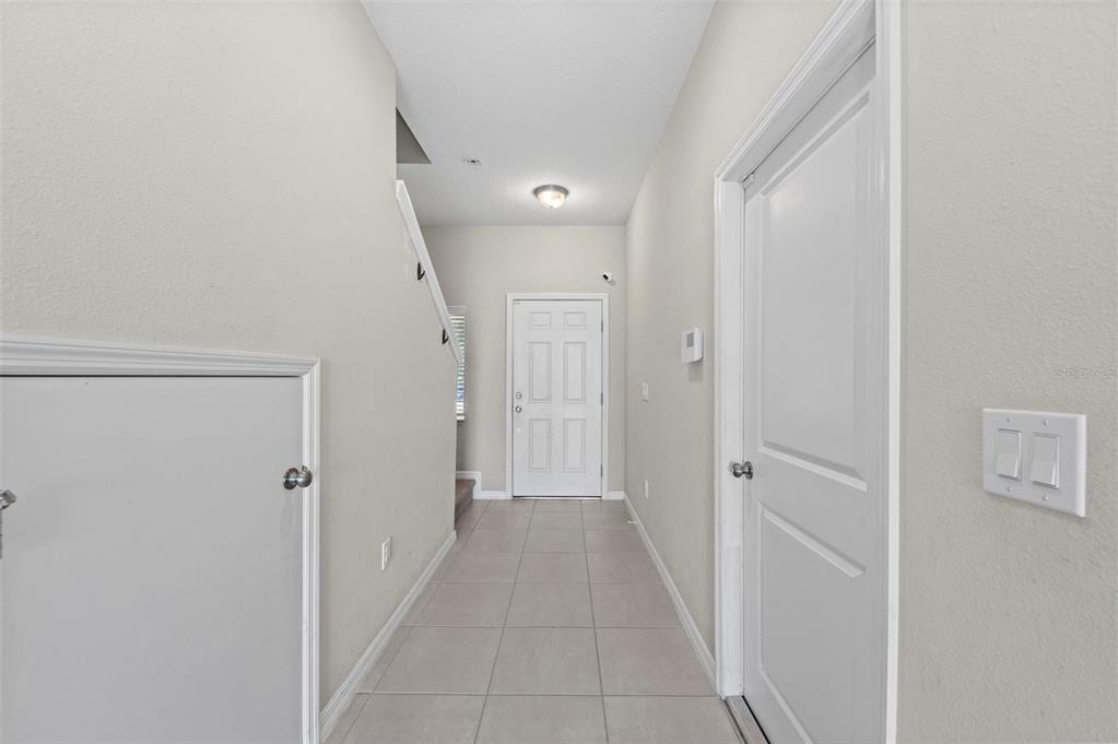 Front door, storage under stairs, garage door exit