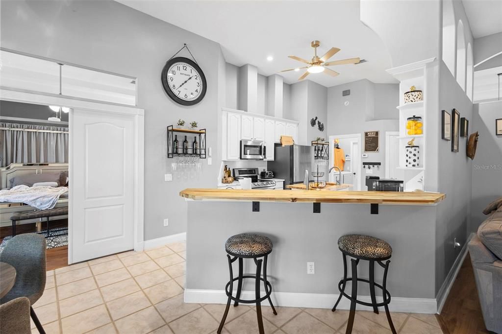 The breakfast bar and kitchen island feature butcher-block tops.