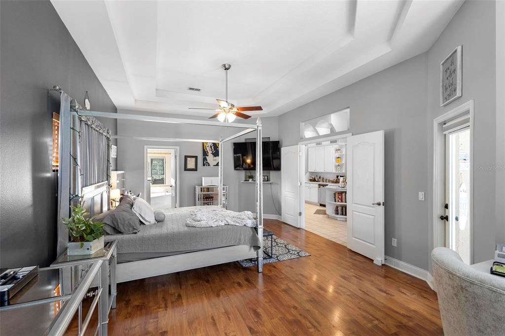 The primary bedroom suite with beautiful tray ceilings towards ensuite bath.