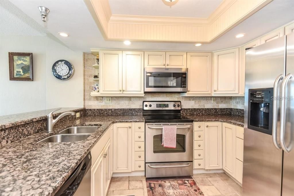 Beautifully upgraded kitchen with granite countertops, stainless steel appliances, and elegant cabinetry, perfect for any home chef.