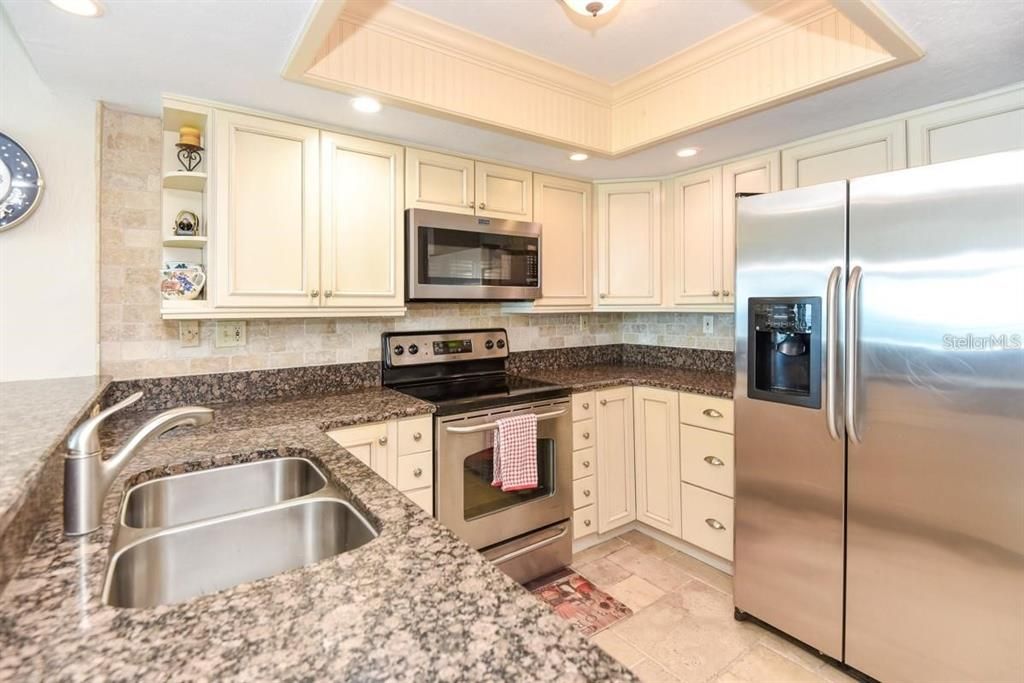 Beautifully upgraded kitchen with granite countertops, stainless steel appliances, and elegant cabinetry, perfect for any home chef.