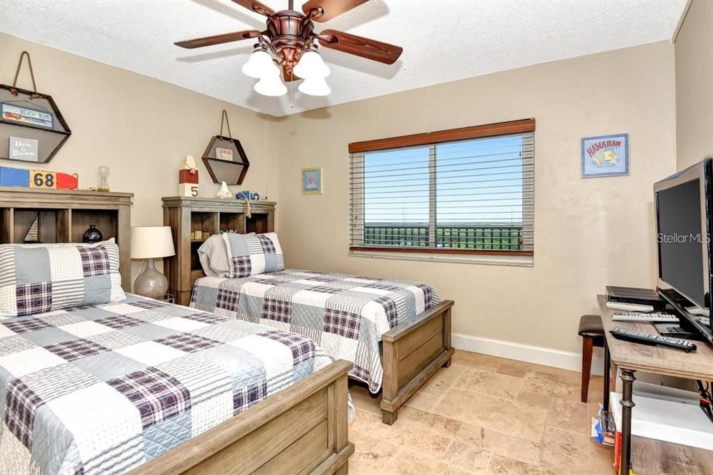 Bright and inviting guest bedroom featuring twin beds, charming decor, and ample closet space for ultimate comfort.