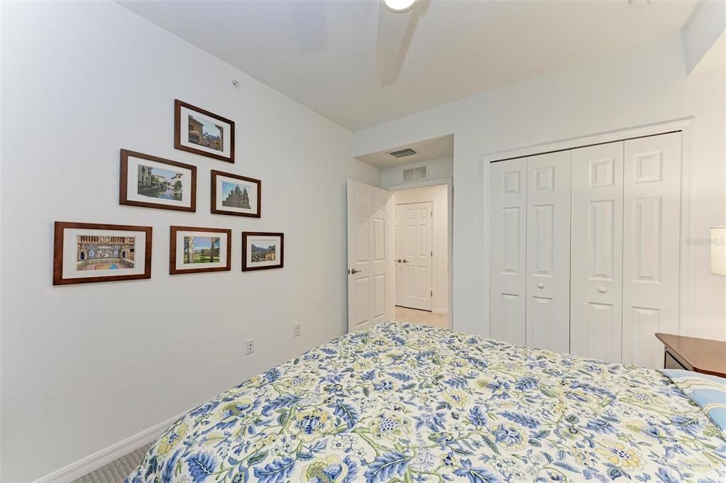 Bedroom 3 has a large closet with custom shelves and the door visible in the hallway in a storage closet that has shelves put in by the owner for linens or cleaning supplies