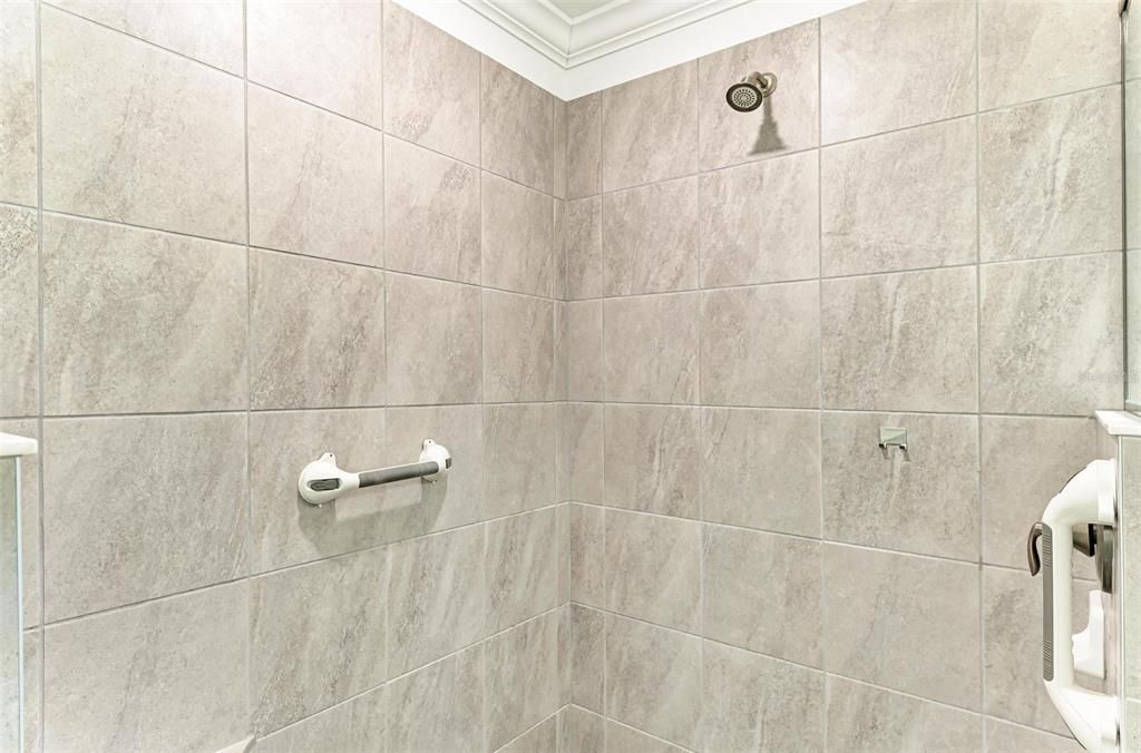 Walk in Shower has removable hand rails and a tiled seat for bathing safety and securely