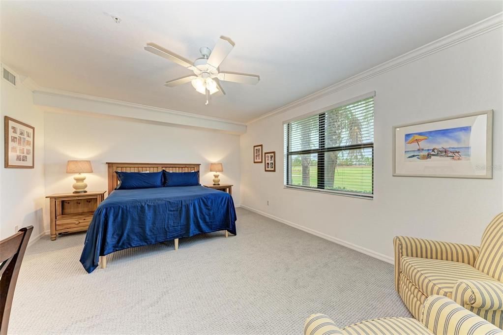 First look entrance into the Primary Bedroom which has new carpet, a new fan and unobstructed view to the golf course