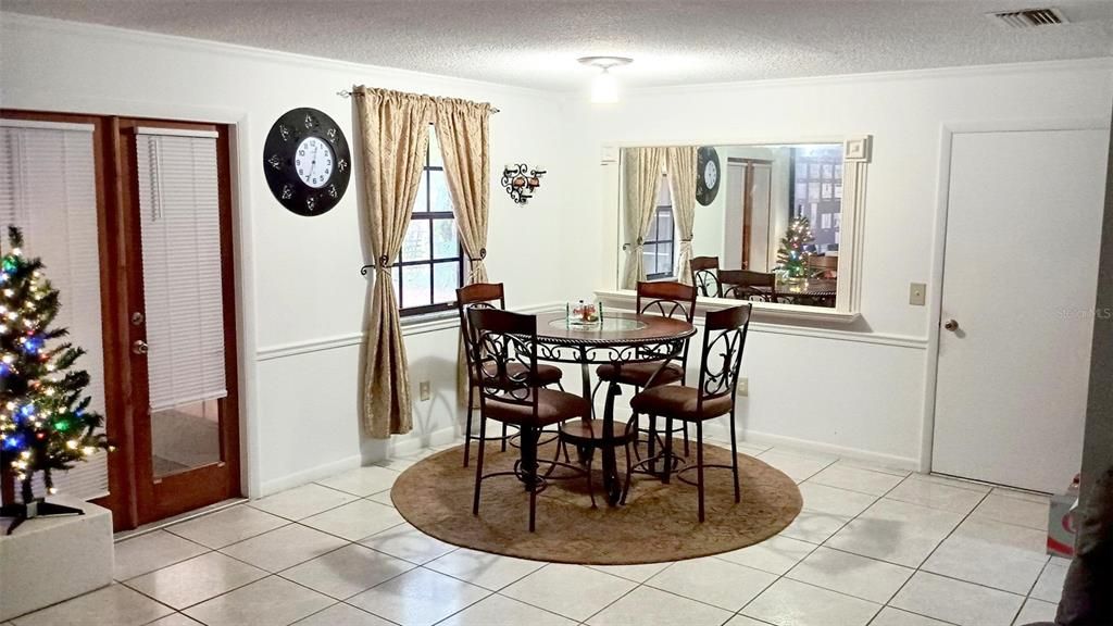 Dining area. French doors at left lead to screened porch. Door at right leads to garage.