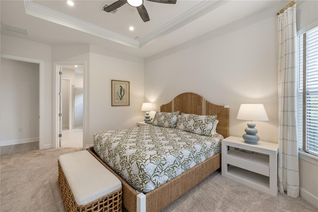 The primary's suite is a luxurious retreat with try ceiling and crown molding.