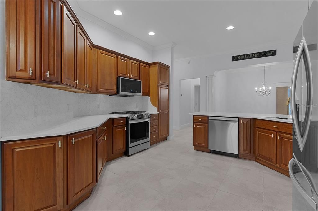 PLENTY OF BEAUTIFUL WOOD AIR-CIDER CHERRY CABINETS WITH CROWN MOLDING AND QUARTZ COUNTER TOPS AND  MATCHING BACKSPLASH