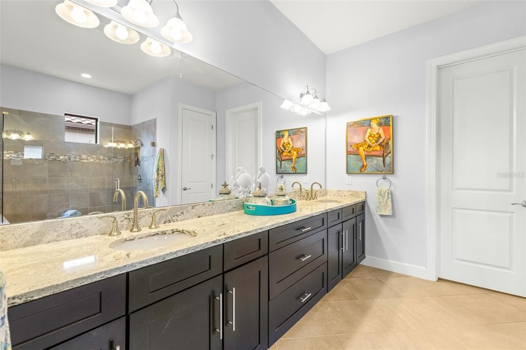 Primary bathroom with dual sinks and walk-in closet