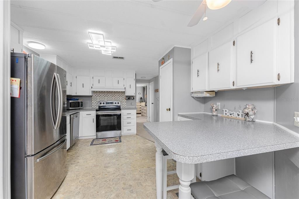 The kitchen features new LED lighting, a ceiling fan and vinyl flooring.