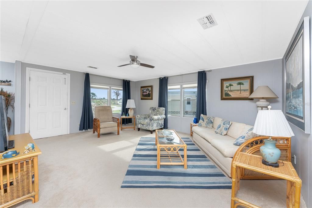 The living room has carpeted flooring and a new ceiling fan.