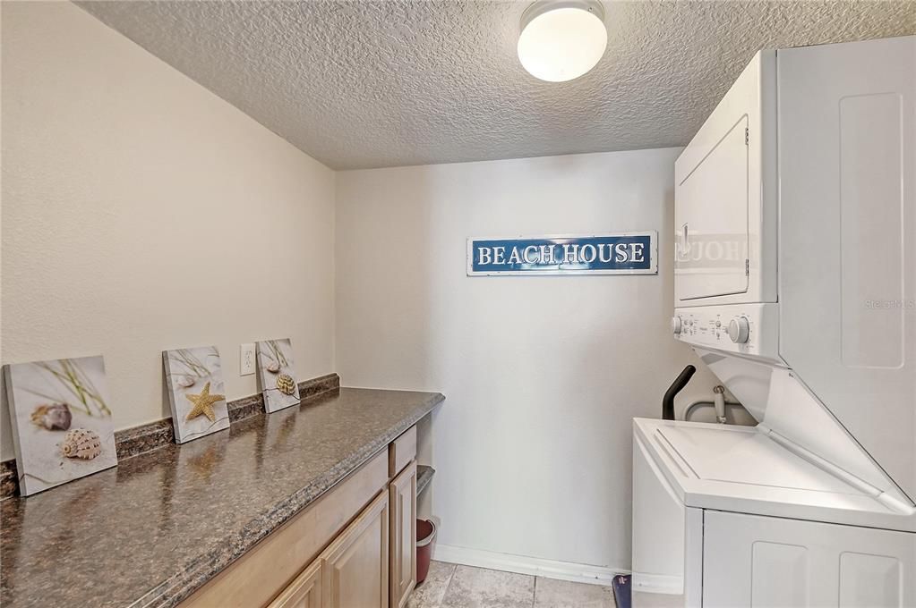 Laundry room with stackable washer/dryer and added storage.