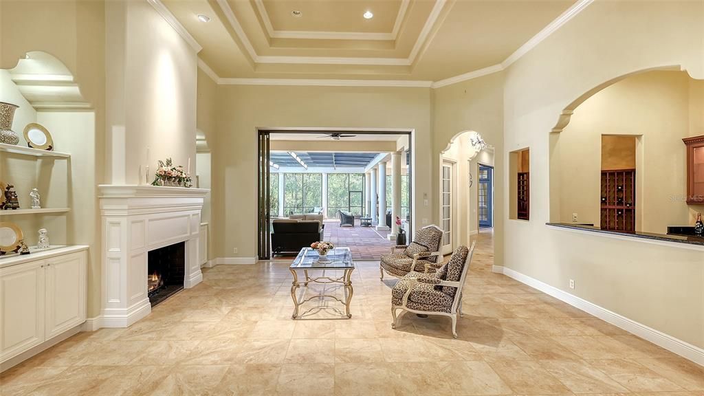 Coffered ceilings with elegant crown molding and disappearing sliders - perfection.  Note the 1st Butler pantry and wine cellar to the right.