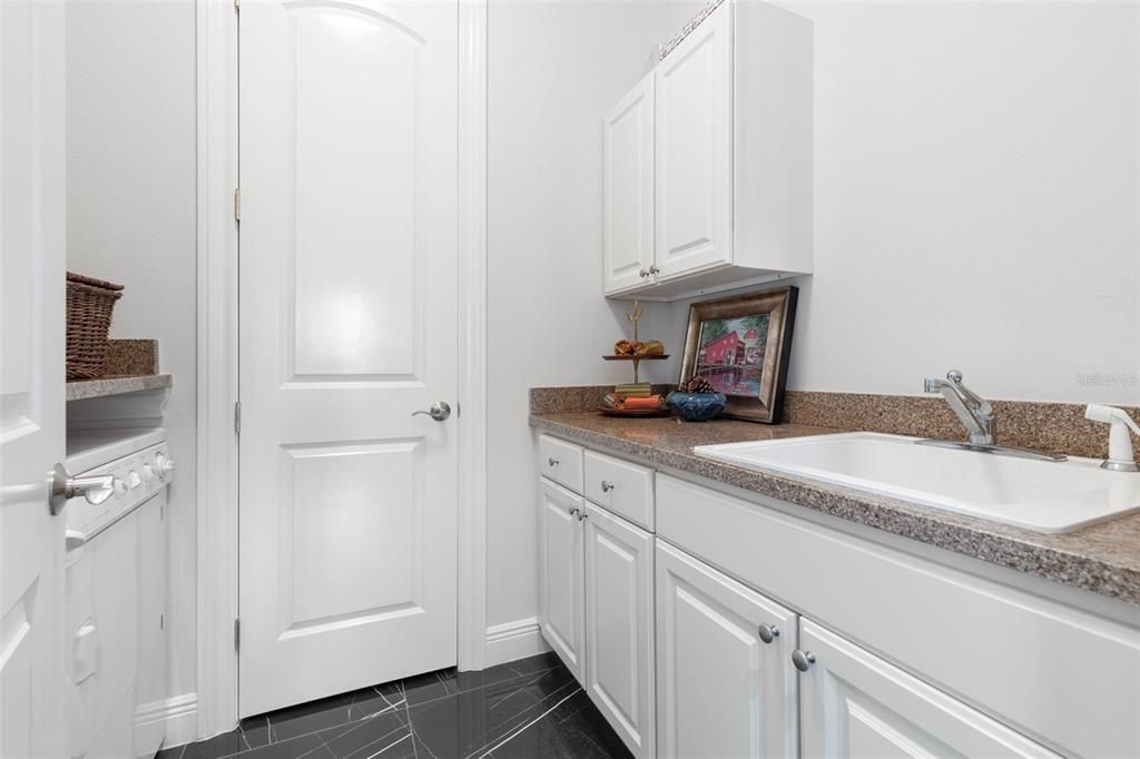 Laundry room with sink and upper and lower cabinets