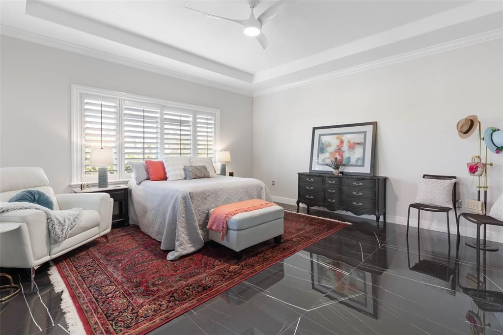 Primary Bedroom with tray ceiling and ceiling fan