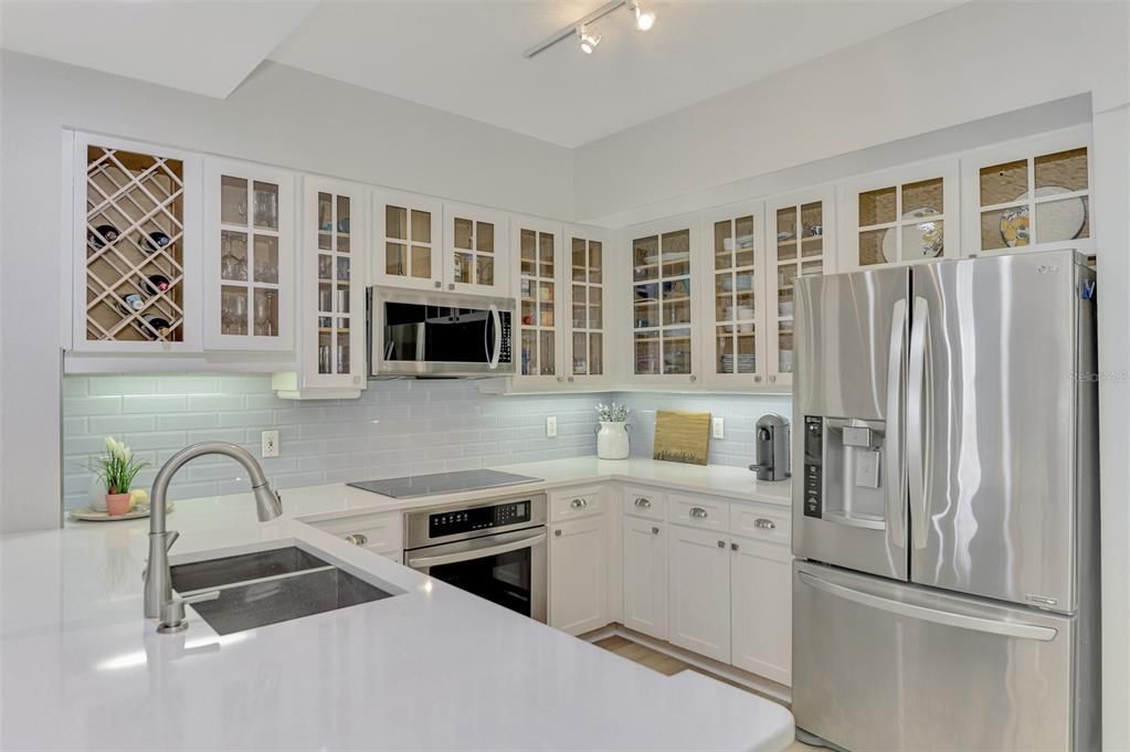 A fully upgraded kitchen with display cabinets, lots of storage and stainless steel appliances.