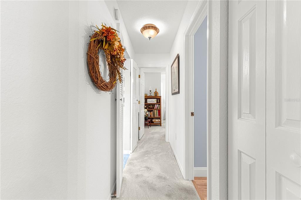 split bedroom layout.  this area is just off the kitchen w carpeted bedrooms, closet and guest bath with shower/tub combo.