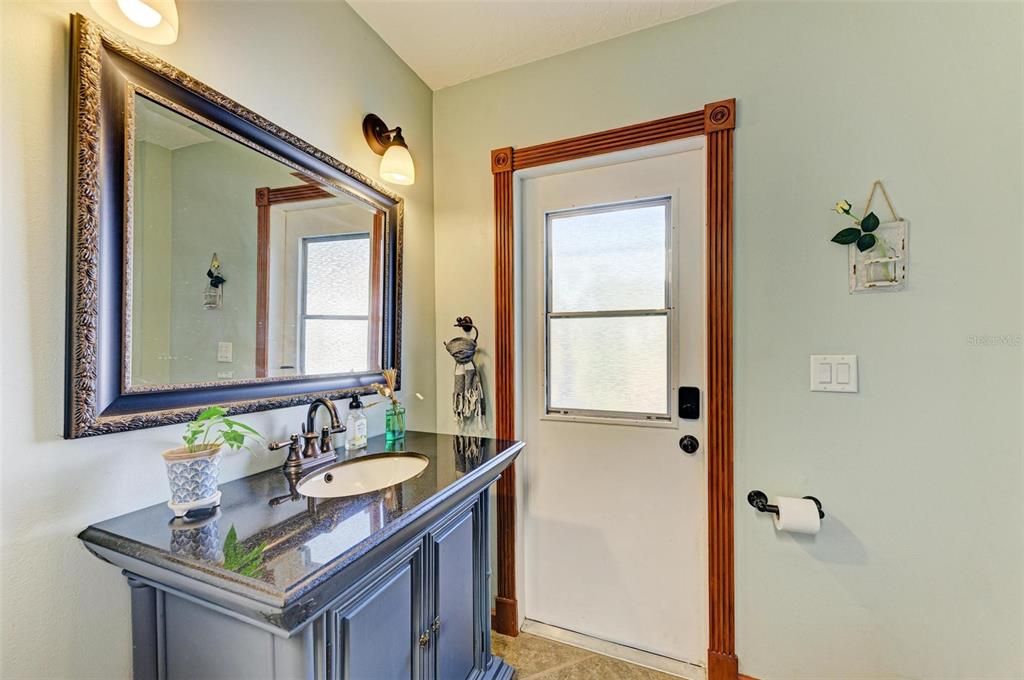 half bath off the laundry room with outside access from pool or the detached accessory building/garage