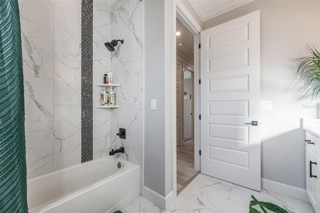 Tub with custom wall tiling floor to ceiling.