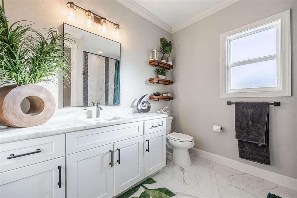 Full bathroom, tiled floors, marble counter was continued (matching Kitchen), upgraded mirrors, floating shelves.