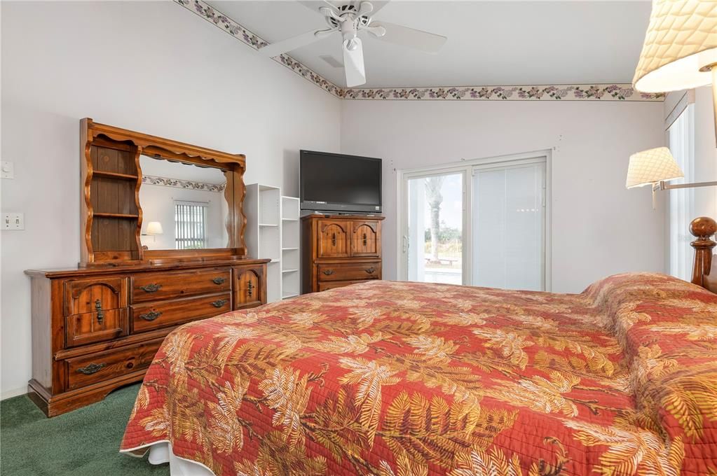 Master bedroom with view of pool and pond