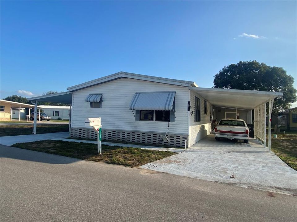 Front view of home with carport on each side of the home.