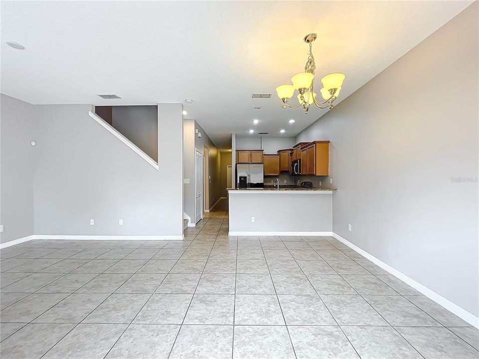 Showing the length of the home from the back sliding glass doors, past the kitchen, to the front door.