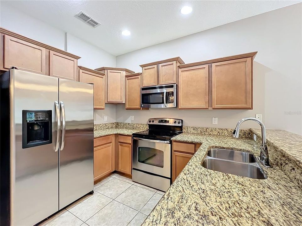 The kitchen has granite countertops which blend in with the other colors of the kitchen.