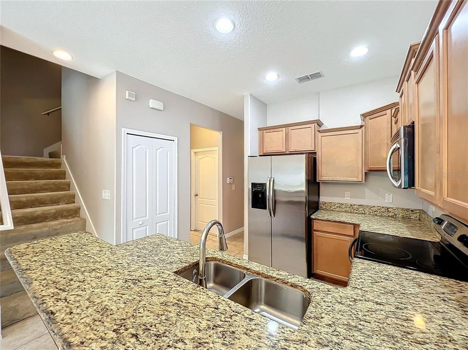 Looking from the kitchen and breakfast bar to the stairway.