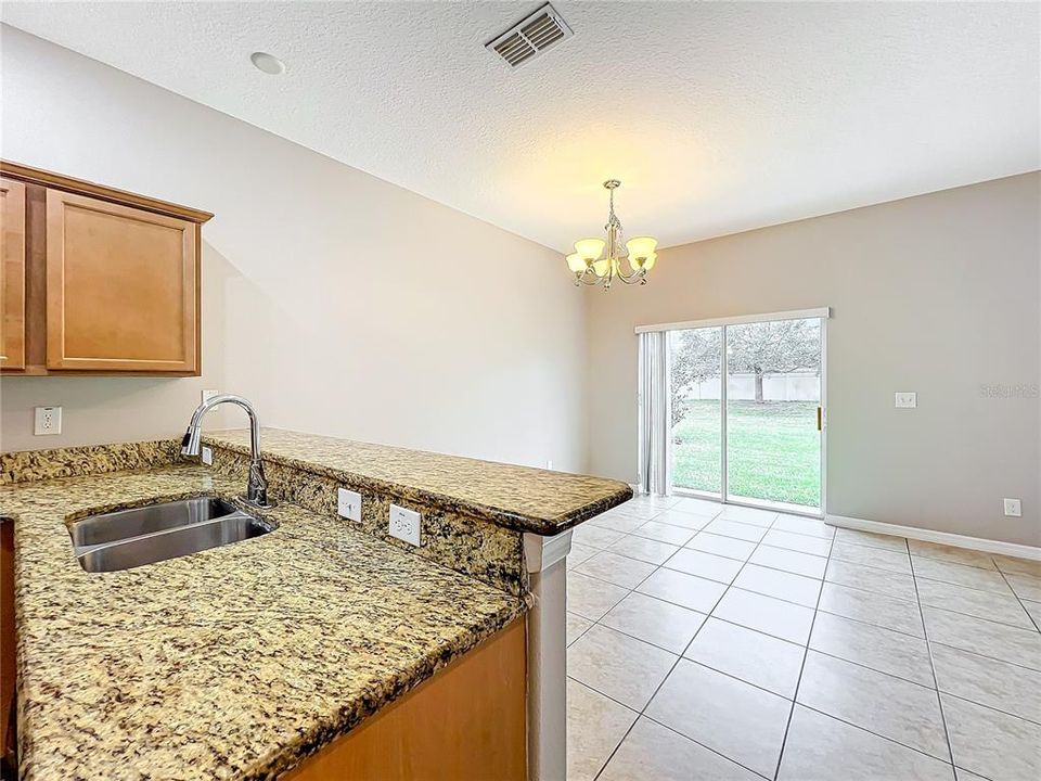 Looking from the kitchen to the open dining/living room area and out to the backyard.