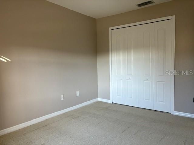 Another view of the guest bedroom that's been freshly painted, new baseboards, and new carpet.