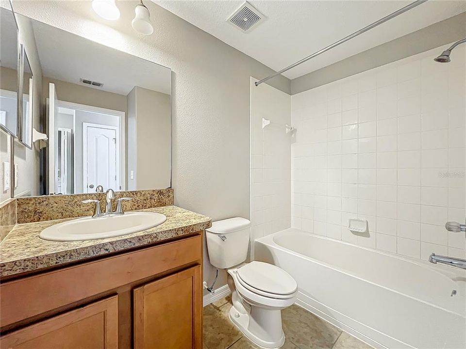 The guest bathroom has a bathtub with shower.