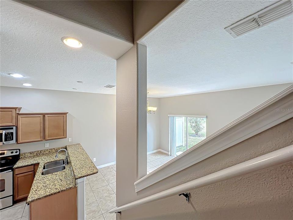 Looking down the stairs to the kitchen and dining area.