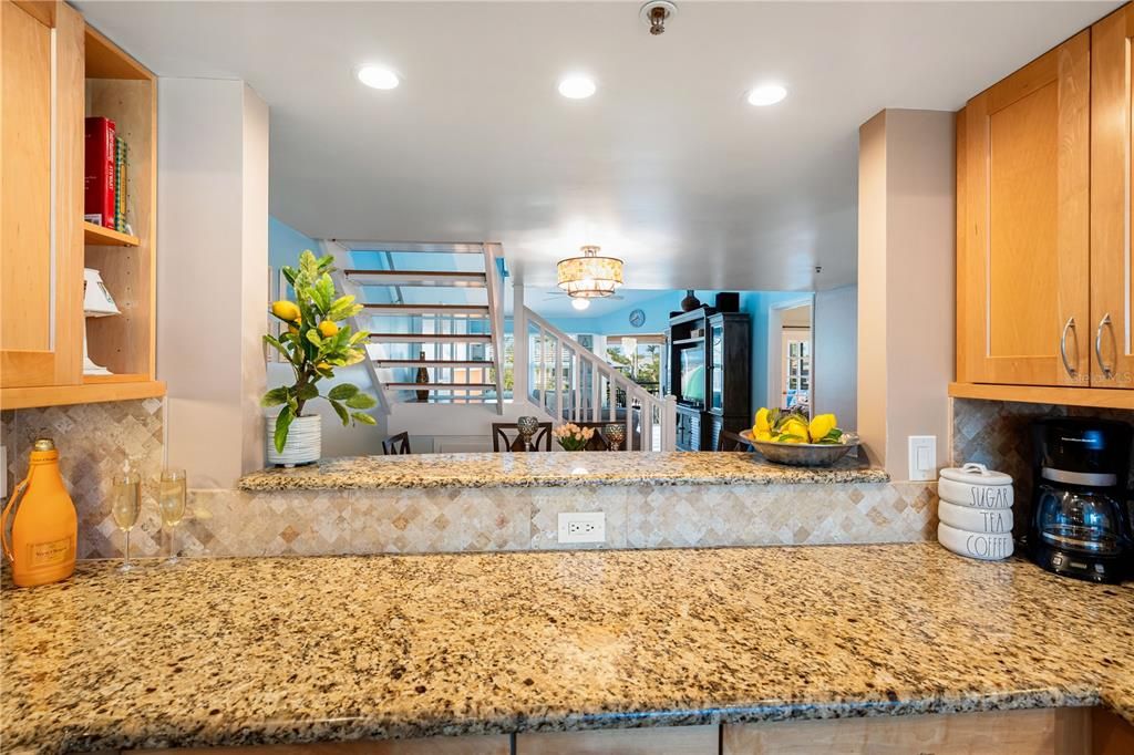 Kitchen features granite counter tops, tile backsplash, newer stainless steel appliances, and pass-through to breakfast bar.