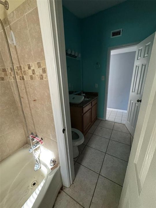 tub with shower curtain also accessible from hall bath