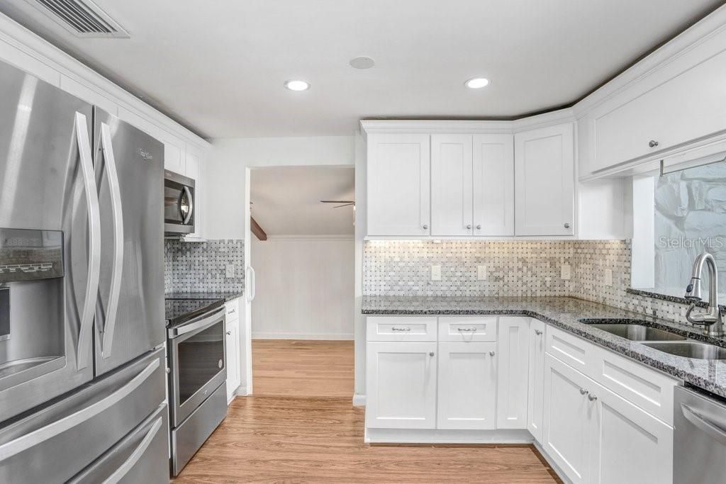 Kitchen with new back splash, granite, cabinets and stainless steel appliances