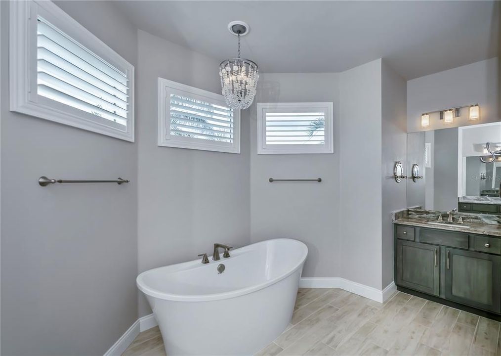 A beautiful chandelier gives the garden tub a glamorous feel