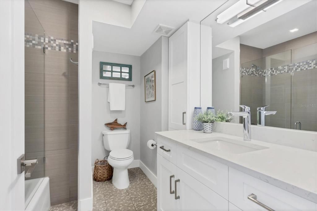 Guest Bathroom with glass tub/shower and plenty of cabinets