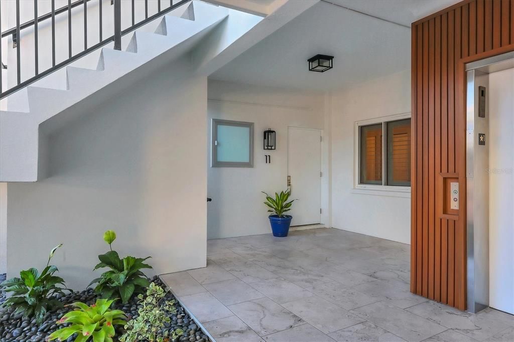 Entrance with new tile and wood paneling around elevator