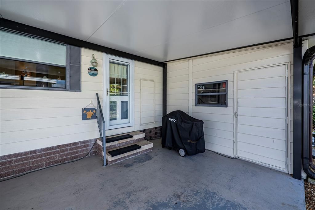 Carport is side door access to main house into kitchen and door to workshop