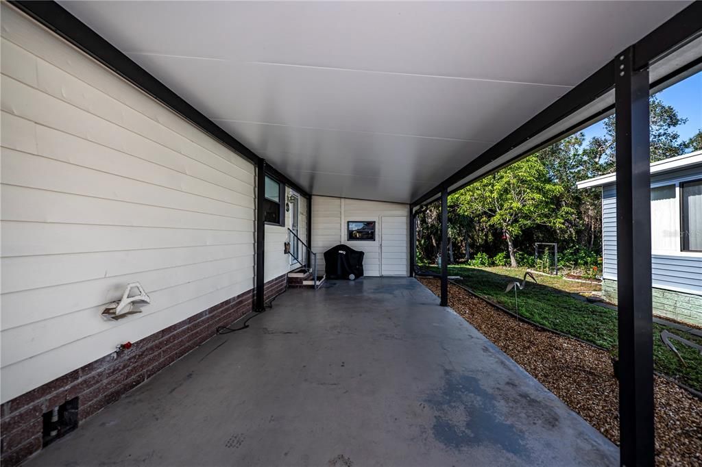 Carport is side door access to main house into kitchen and door to workshop