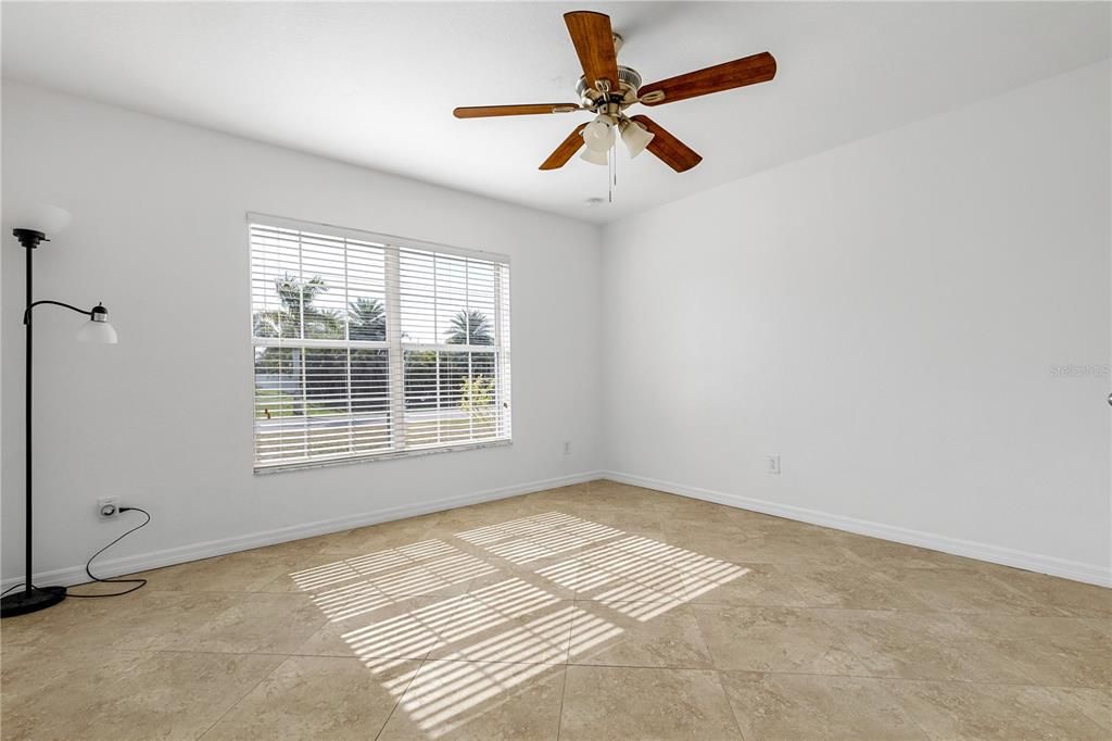 Front large bedroom with ceiling fan and tile flooring and large closet