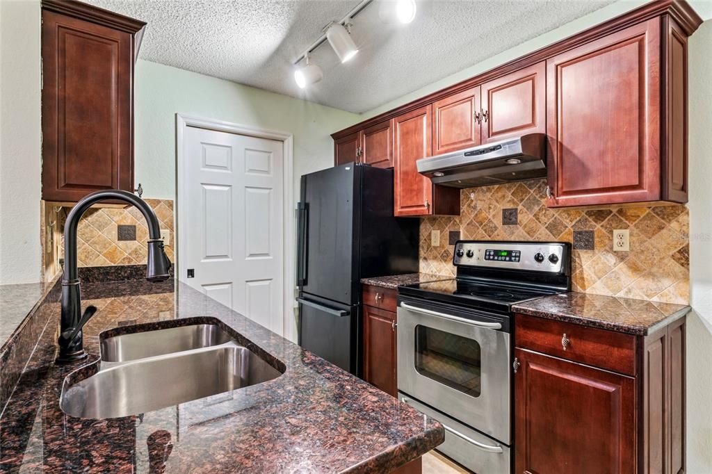 Kitchen has granite countertops and access to the laundry closet.