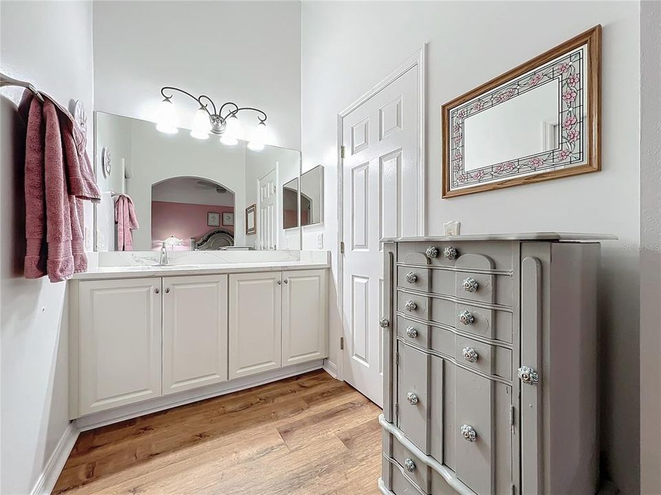 Vanity area has been remodeled with a high counter and quartz countertop.  The walk-in closet door is shown on the right.