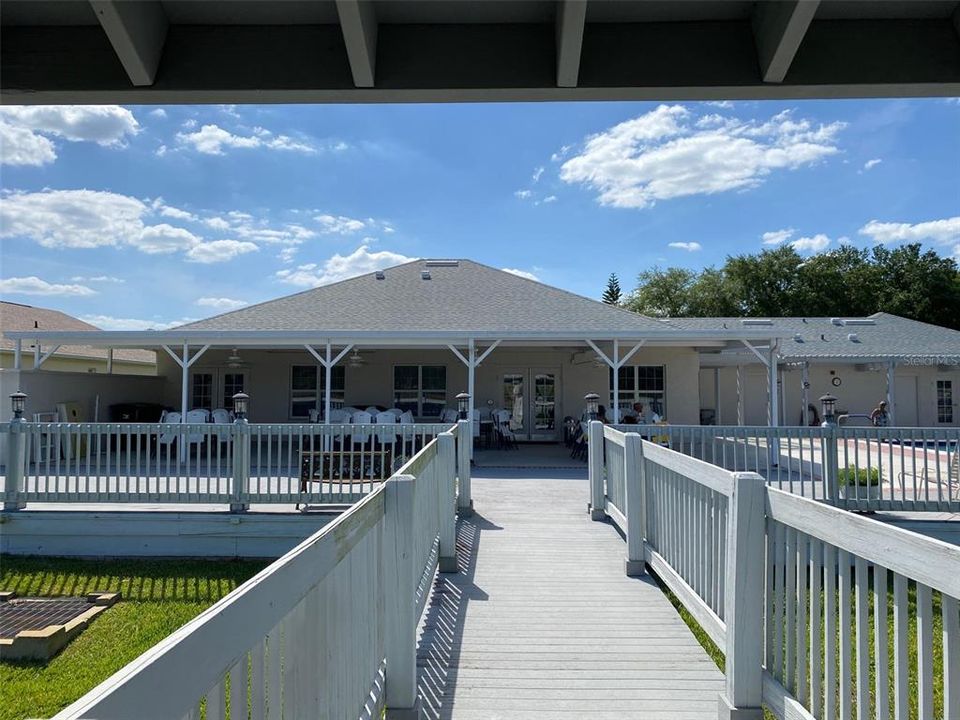 Looking back to the clubhouse and pool, there is a large patio area to sit under and stay if you need protection from the sun.